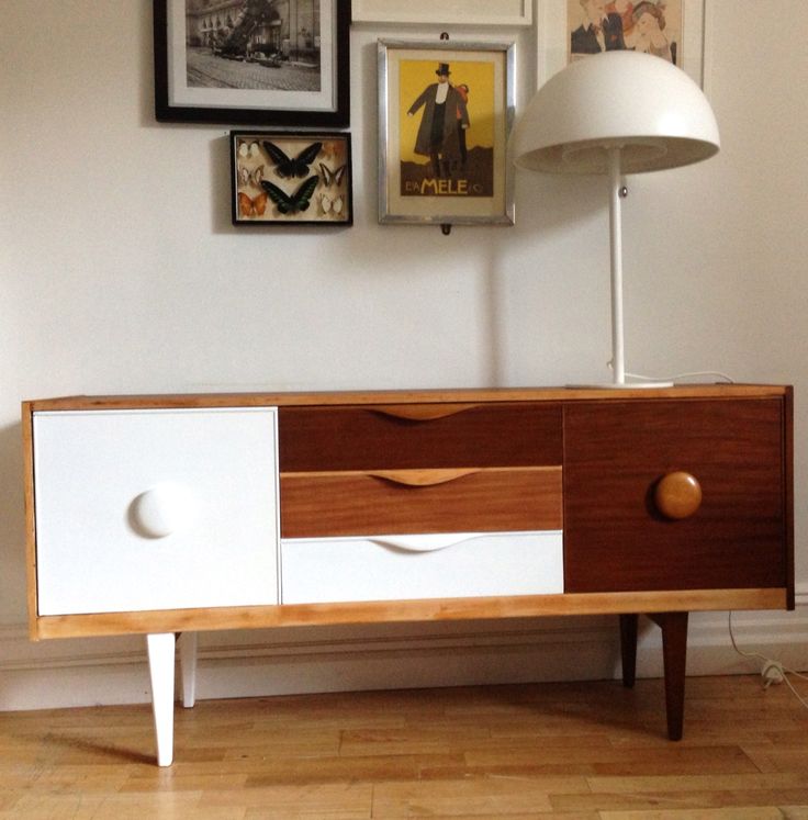 A beautiful mid century modern sideboard with a white and a dark stained door, three tiny drawers in white, light and dark stained and cool knobs