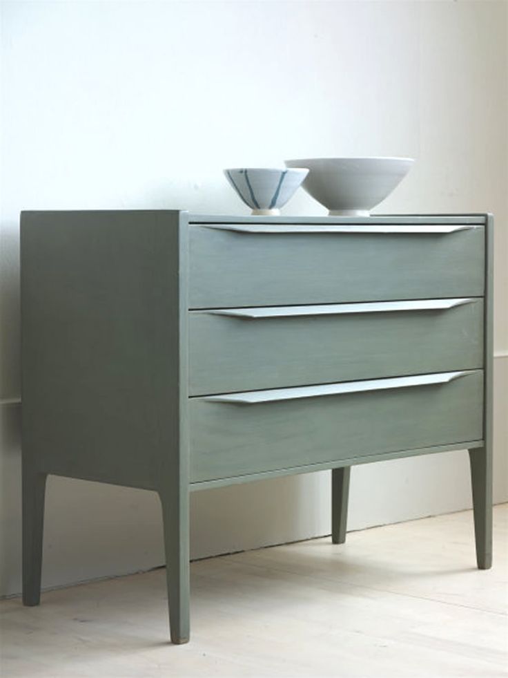 A laconic olive green mid centurymodern sideboard with drawers and pulls on tall legs will be a nice idea for a Scandinavian interior
