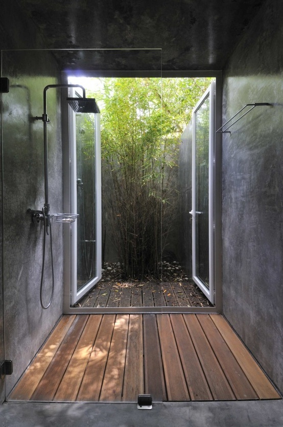 an indoor shower that can be opened to outdoors and fresh greenery growing here