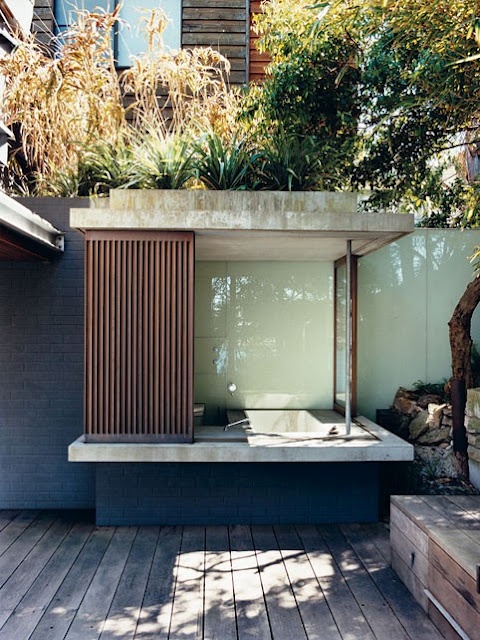 An outdoor bathroom with a built in concrete bathtub that can be completely hidden