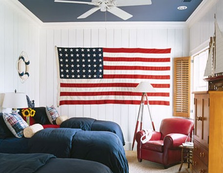 Patriotic theme is always great for boys rooms. An American flag that occupies the whole wall is in harmony with other colors in this room.