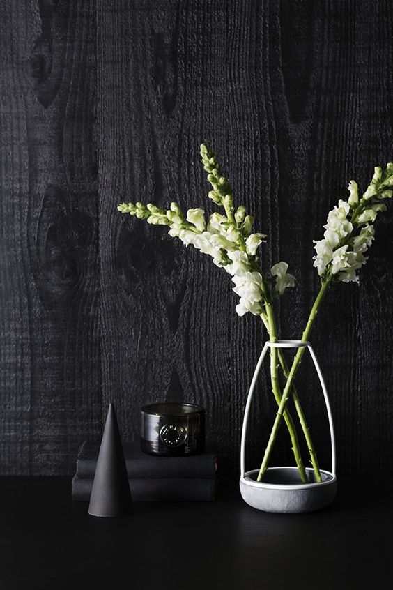 a grey frame only vase with white blooms and a catchy glass candleholder for laconic and minimal decor