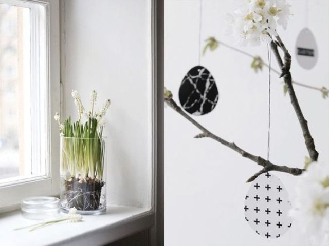 a sheer glass with bulbs and some blooming branches with black and white eggs of cardbord for a spring and Easter feel