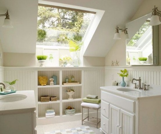 a small neutral attic bathroom with a large window, built-in storage spaces and two vanities