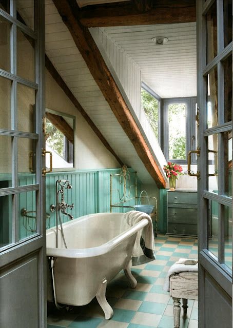a colorful attic bathroom done with wooden beams, turquoise touches and a vintage tub