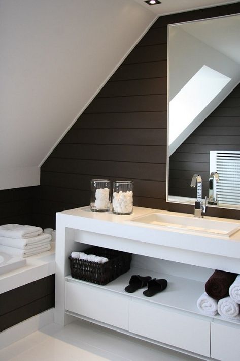 a minimalist contrasting bathroom in dark brown and white, with a large white vanity and white towels
