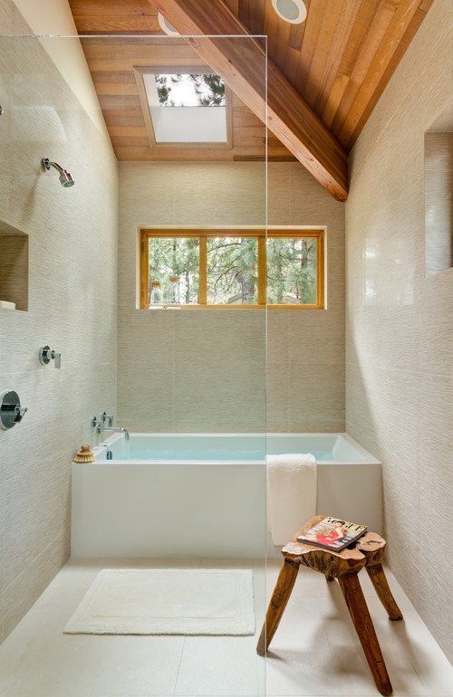 a neutral bathroom with textural tiles, a wooden ceiling and a stool, a shower space