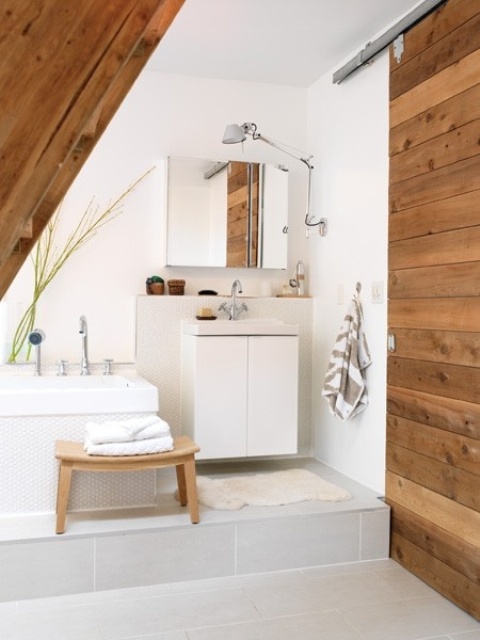 a neutrla bathroom with wodoen touches and furniture, a geometric tub and vanity