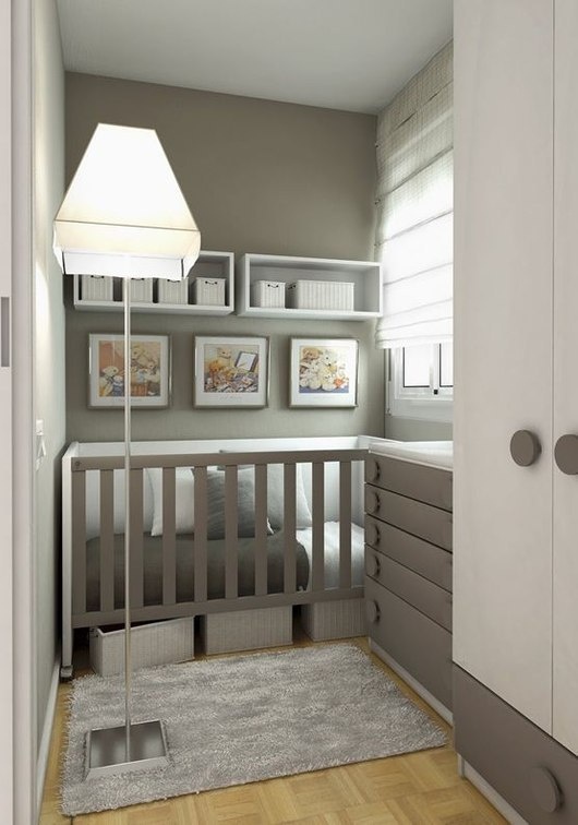 A grey and white small nursery with a built in crib and a grey dresser that doubles as a changing table and shelves with baskets for storage