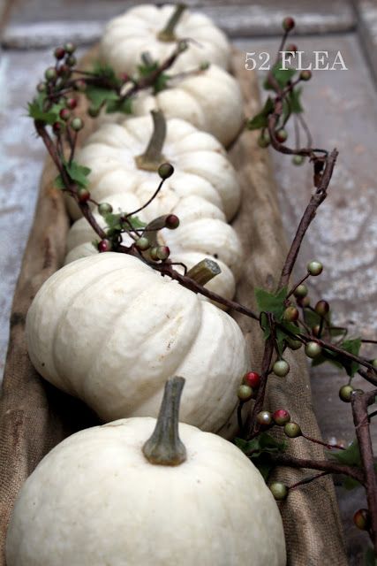 a bread bowl with white pumpkins and some branches is a rustic fall decoration or a centerpiece that can be DIYed last minute