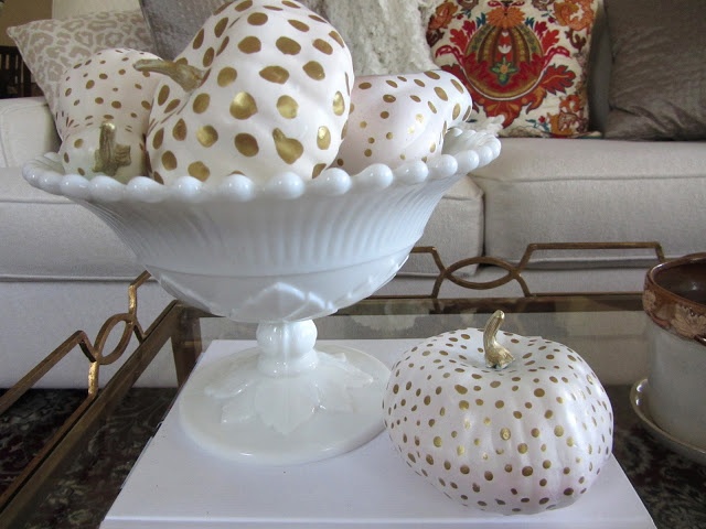 An arrangement of painted white and gold polka dot min pumpkins is a lovely idea to decorate your home for the fall