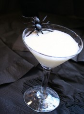 milk in a glass accented with a black spider is a bold and stylish idea for Halloween party that is easy to realize
