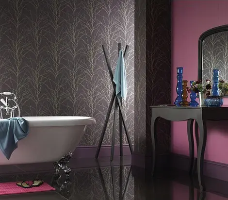 a dramatic and moody purple bathroom with dark furniture, a vintage clawfoot bathtub and a statement wall with printed wallpaper