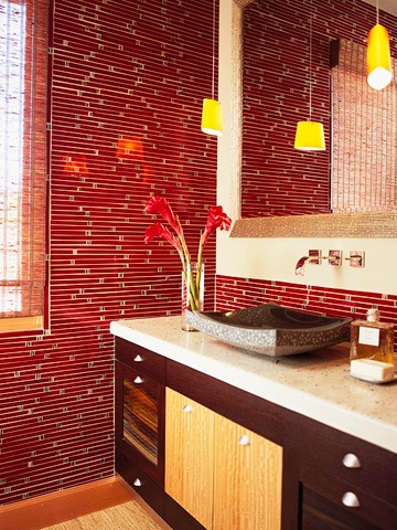 a refined bathroom with red tiles, a dark stained vanity and catchy stone sink plus pendant lamps