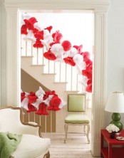 red and white paper bells decorating the banister are amazing to add a bold holiday touch to the space
