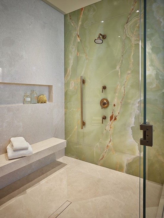 a beautiful contemporary shower space with neutral stone and a green onyx accent wall looks adorable and chic
