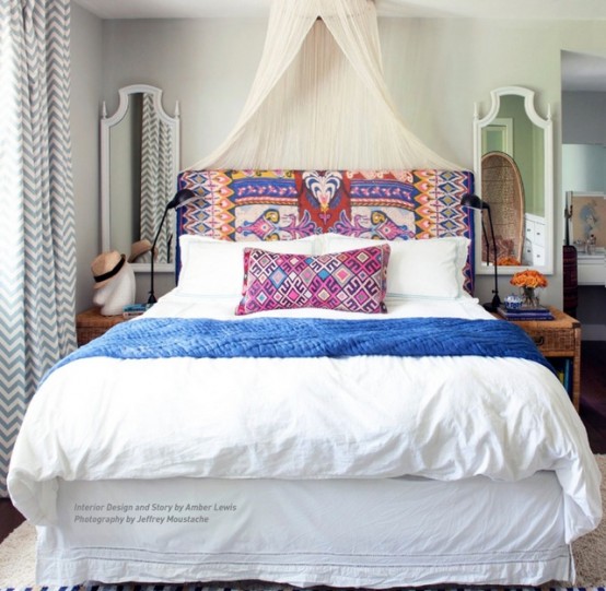 Bright boho color palette should always come with something soft and neutral. White sheets, walls and a canopy looks well with such textile headboard and throw pillows.