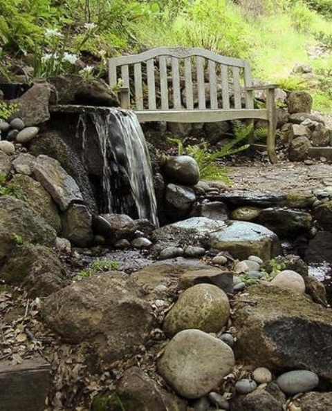 Don't forget to put a bench near your backyard waterfall. You'll definitely enjoy the sound of falling water while relaxing on it.