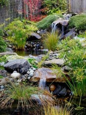 a chic Japanese front yard with waterfalls, rocks, pebbles, greenery and moss around for a relaxing and calming feel