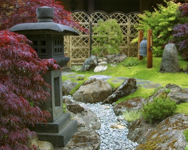 Green grass, pebbles, rocks, red maples, a stone lantern and a large bell create a very beautiful and zen like look