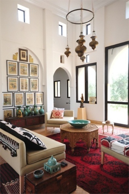 a beautiful Moroccan living room with pendant lamps, modern furniture and carved tables plus patterned textiles