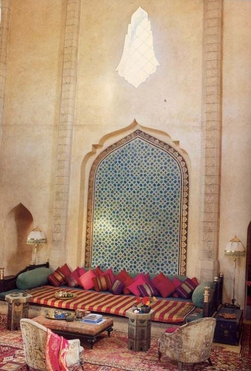 a bright Moroccan living room with colorful pillows and cushions, rugs and mosaics on the wall
