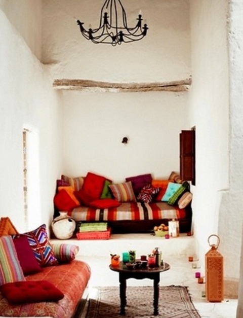 a white living room with plaster walls, colorful and printed textiles and pillows and traditional lanterns