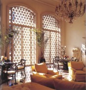 a neutral living room with gorgeous carved window screens that remind of Moroccan style