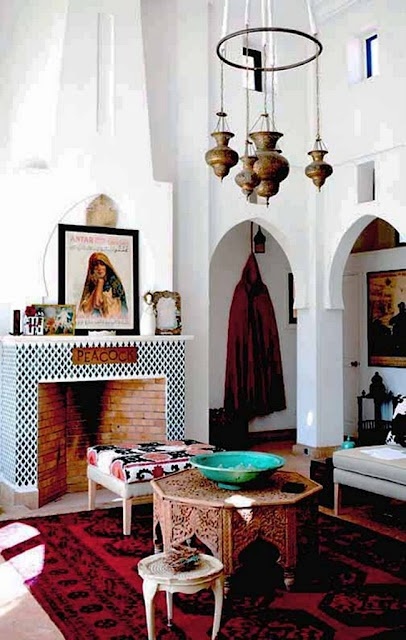 a rather neutral Moroccan living room with carved coffee tables, pendant lamps and bold textiles