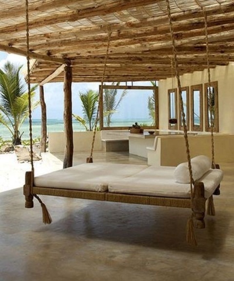 a hanging bed fully covered with jute rope and hanging on it and with white cushions is ideal for tropics