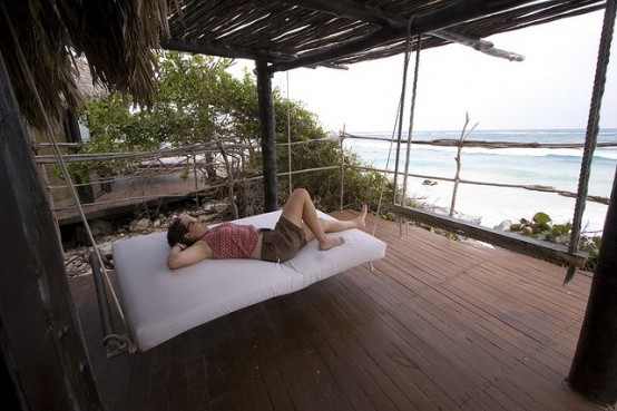 a hanging bed on ropes with a white cushion will let you lie on it and relax whenever you want