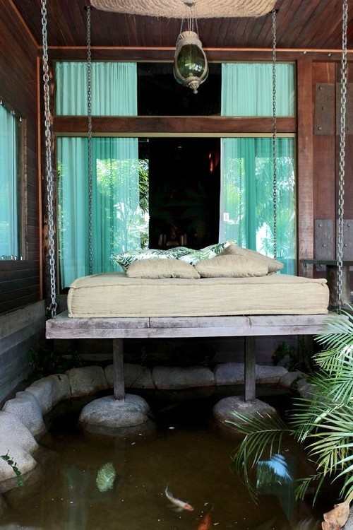 a whitewashed wooden bed hanging on chains is a cool idea for many outdoor spaces and can be hung over a pond