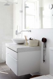 a laconic Nordic bathroom with mini white tiles on the walls and vanity, a bowl sink and a large mirror