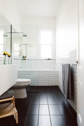 a Scandinavian bathroom in black and white, with natural wood and printed towels