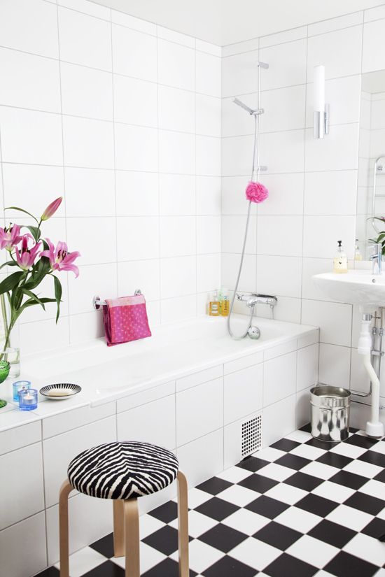 a black and white Nordic bathroom spruced up with bright pink touches and prints