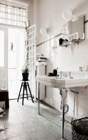 a vintage Nordic bathroom done in a neutral color scheme, a vintage stool, sink and a mirror with a shelf