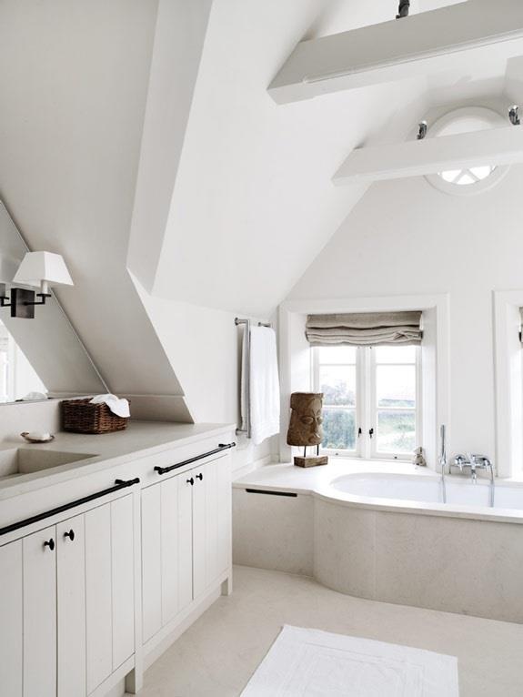 A vintage inspired Scandinavian bathroom with a large vanity, wooden beams and a tub clad with tiles