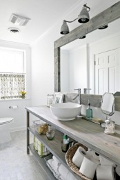 a vintage Nordic bathroom with a wooden vanity, a large framed mirror and a printed curtain on the window