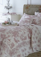 a French chic bedroom with white walls, a refined bed with a painted floral headboard and floral bedding, a creamy dresser and a chic crystal candelabra is amazing