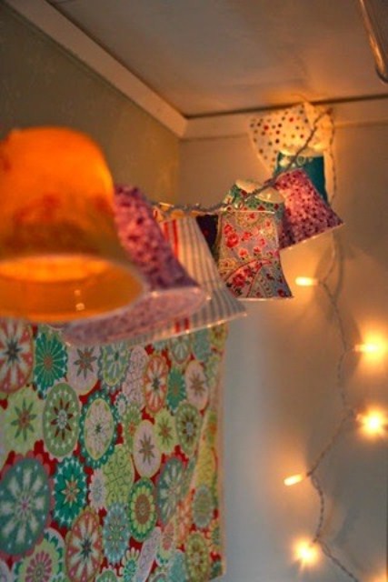 Lights and a garland with colorful lampshades is a pretty vintage inspired idea to illuminate a bedroom