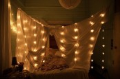 curtains around the bed with star-shaped lights for a romantic feel