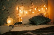 a headboard covered with lights and table lamps for a soft glow in your bedroom