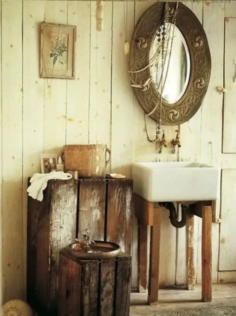 a vintage barn bathroom with whitewashed wooden plank walls, shabby chic furniture, a sink and a vintage mirror