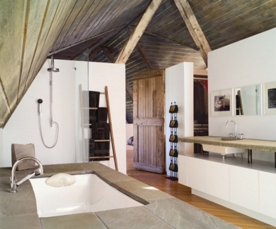a modern rustic bathroom with white walls, a wooden ceiling with beams and a stone clad bathtub plus a raised stone countertop