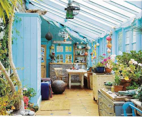 Rustic sunroom In a cottage. Lovely sky blue walls and decorations make the space cool and fun.
