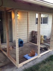 a large cage-like cat patio with a toilet, a scratcher, some bowls and a toilet is a modern space to enjoy fresh air