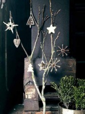 a branch arrangement with white and wooden ornaments instead of a traditional Christmas tree