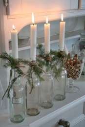 bottles as candle holders wrapped with evergreens and with candles in them for a cozy rustic touch