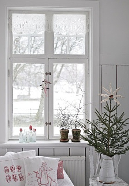 an undecorated Christmas tree in a pot, red and white linens will make the space feel Scandi and Christmas-like
