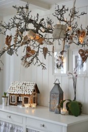 large branches attached to the ceiling, with gingerbread hearts and gift boxes and a large gingerbread house on the table for a Nordic feel